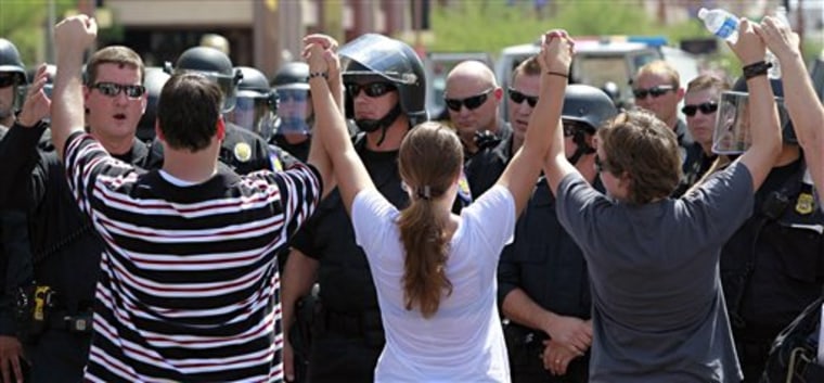 Protesters join hands as police block the street in Phoenix on Thursday during a rally against Arizona's new immigration law. 